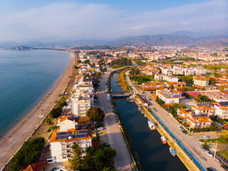 Scenic aerial view of modern cityscape of Fethiye along shoreline of Aegean Sea on sunny winter day, Turkey