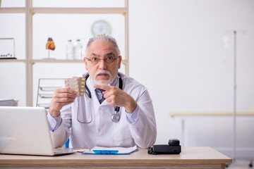 Old male doctor working in the clinic