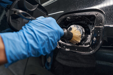 Automotive industry worker carefully detailing car body