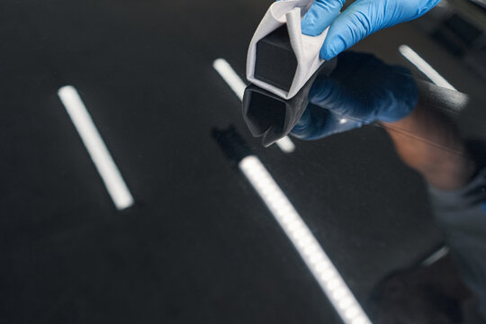 Man car detailing studio worker applying ceramic coating on car