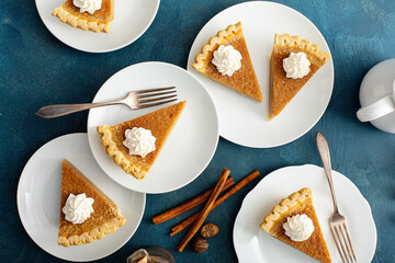 Traditional pumpkin pie with whipped cream and cinnamon