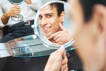Client enjoying his shaved face in mirror