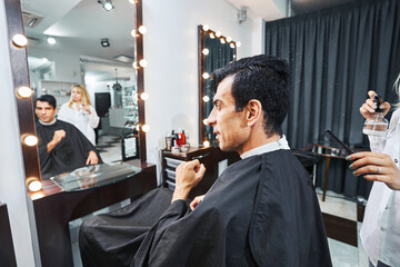 Man in hairdressing armchair getting ready for haircut