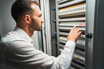 Man system administrator pressing on electrical switch