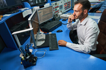 Network administrator speaking on phone while administering data center servers