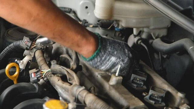 Mechanic is unscrewing the engine cover nut or checking for repair	