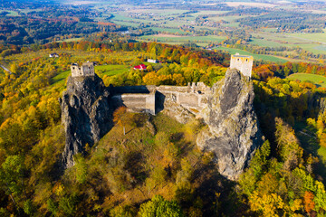 Fototapeta na wymiar Impressive autumn landscape of Bohemian Paradise overlooking ruins of medieval Trosky Castle on tops of two stone crags, Czech Republic..