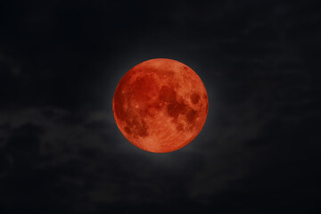 blood moon concept of a red full moon in black sky.