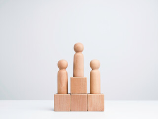 Business competition winner. The wooden figure standing on the winner podium, wood cube block on white background with copy space, minimal style. Goals, success, and leadership concept.