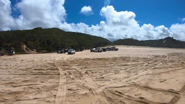 Rear facing driving point of view POV of a busy Queensland beach at popular tourist spot with multiple 4x4 trucks at Fraser Island's Eli Creek - ideal for interior car scene green screen replacement