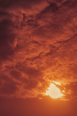 Heavenly landscape with cumulus clouds and with sun during a reddish-pink dawn in autumn. Selective focus.