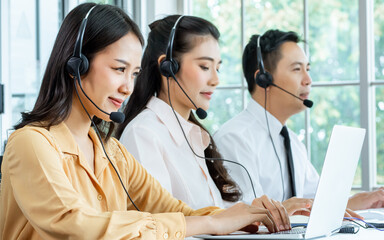 Focus Asian beautiful attractive female call center cheerful smiling with headsets, sitting,...