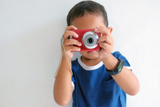 child taking photo using camera