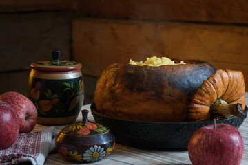 Baked pumpkin with millet porridge. Still life in a rustic style.