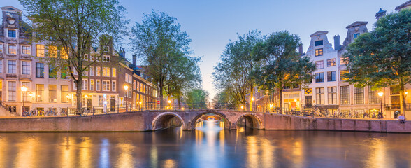 Fototapeta na wymiar Amsterdam. Panorama view of the historic city center of Amsterdam. Traditional houses and bridges of Amsterdam. A European travel to a historic city. Europe, Netherlands, Holland, Amsterdam.