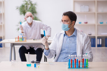 Two male chemists working at the lab during pandemic