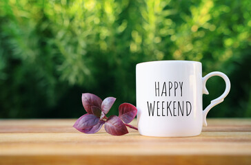 coffee cup with the text happy weekend on wooden table outdoors - obrazy, fototapety, plakaty