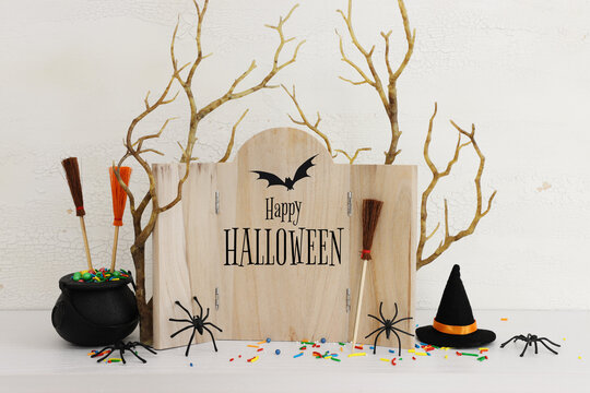 holidays image of Halloween. spiders, bare trees and wooden board frame with text