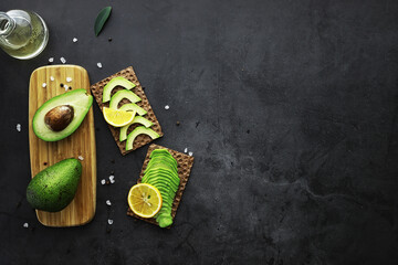 Avocado cooking recipes. Ripe green avocado on a wooden cutting board for serving.