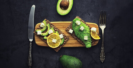 Avocado cooking recipes. Ripe green avocado on a wooden cutting board for serving.