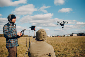 Man pilot controlling quadcopter drone with remote controller pad. © primipil