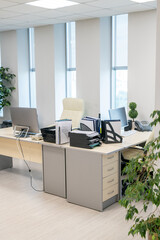 Large modern office with two desks, computers, documents and other supplies during break