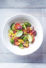 Simple Salad with Green and Kalamata Olives, Cucumber, Cherry and marinated Tomatoes, Capers and Jalapeno Pepper. Bright wooden background. Top view. Close up.  