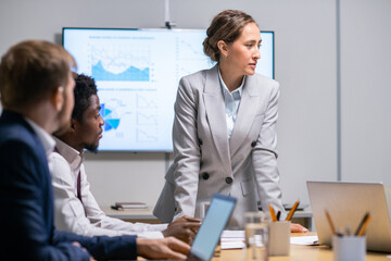 Young confident teacher interacting with employees at seminar or business training