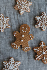 Homemade Christmas gingerbread cookies on grey linen table cloth. Man and snowflakes. Happy Christmas holidays composition. Flat lay, top view