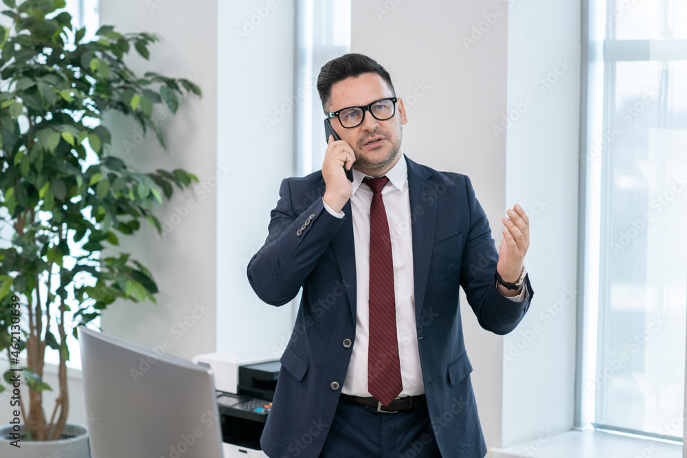 Aufkleber confident broker in formalwear consulting client on the phone while working in office