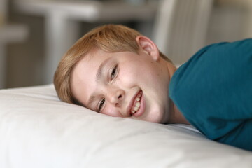 Fototapeta na wymiar Portrait of young boy smiling and waking up. Family, vacation, childhood, sleep concept.