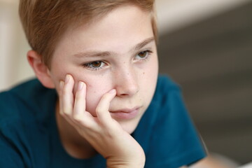 Portrait of thoughtful teenage young boy on light background