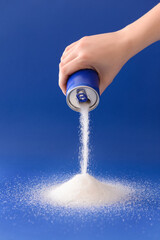 Woman sprinkling sugar from tin can on color background