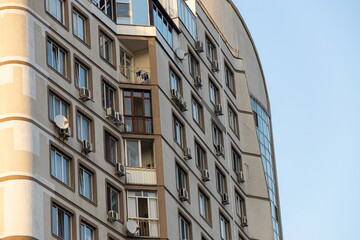 Multi-storey house with lots of windows, balconies and air conditioning. Detail photo of old skyscraper