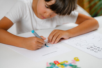 Obraz na płótnie Canvas Child coloring shapes in a preschool assessment test.