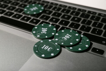 Poker chips on laptop, closeup