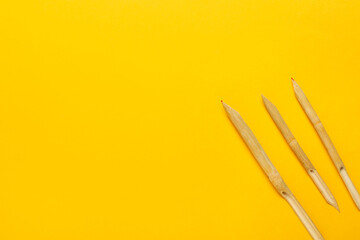 Wooden dip pens on yellow background