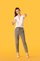 Young woman with imaginary steering wheel on color background