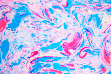 Fototapeta premium Variegated colored background, paint particles on white. Dye stains on the surface of the liquid. Abstract background.