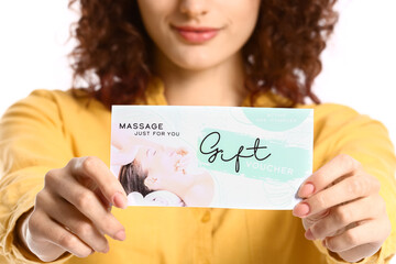 Pretty young woman with gift voucher on white background
