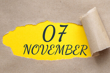 november 07. 07th day of the month, calendar date.Hole in paper with edges torn off. Yellow background is visible through ragged hole.Autumn month, day of the year concept