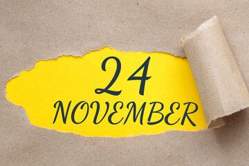 november 24. 24th day of the month, calendar date.Hole in paper with edges torn off. Yellow background is visible through ragged hole.Autumn month, day of the year concept