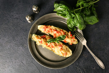 Plate with quinoa stuffed zucchini boats on dark background