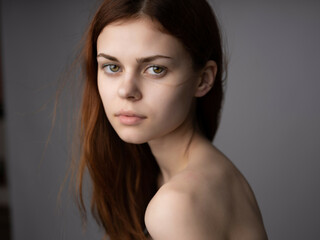 Naklejka premium redhead woman bare shoulders clear skin posing studio