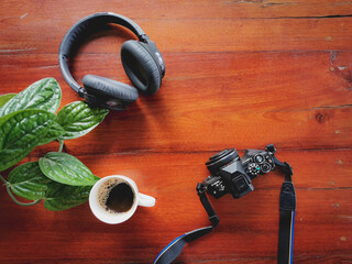 Headphones  and coffee on wooden desk table.