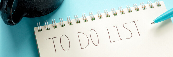 To do list panorama with the handwritten words, a notepad, and a blue pen. The concept of planning,...