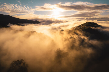 The sun rises in the mist and mountains in the morning