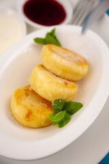 A portion of three round curd cheese pancakes on a white plate. Healthy breakfast. Food background