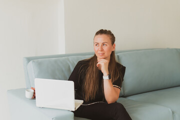 portrait of business young woman with laptop sitting on sofa