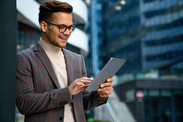 Portrait of successful man using digital tablet in urban background. Business people concept